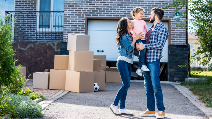Foto de una familia feliz frente a su nueva casa, destacando los beneficios del crédito Infonavit para lograr este sueño.
