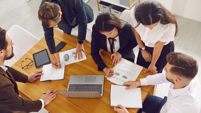 Un equipo de profesionales analizando datos en una pantalla, destacando medidas de protección financiera.