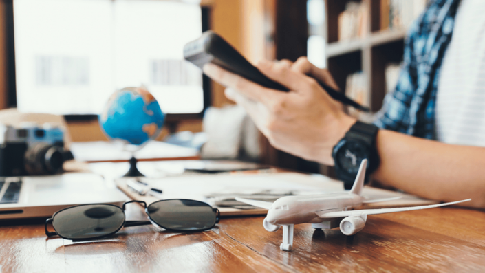 Un viajero revisando ofertas de vuelos y hospedajes: estrategias para planificar un viaje aprovechando descuentos y promociones.