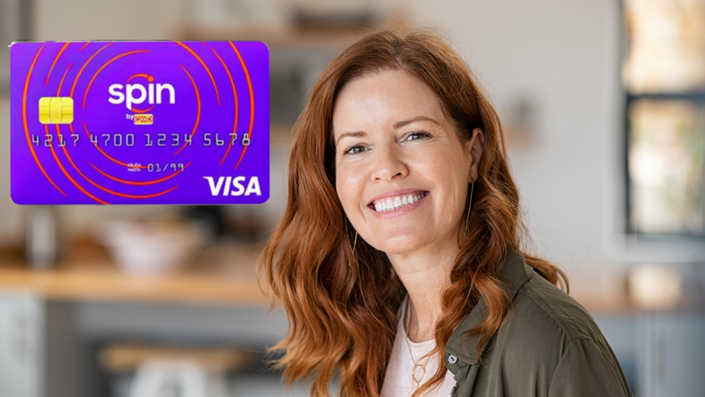 Mujer sonriendo al girar la tarjeta de crédito
