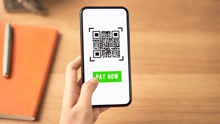 Un código QR en un teléfono móvil para realizar una transferencia SPEI, destacando la modernización y facilidad del sistema.
