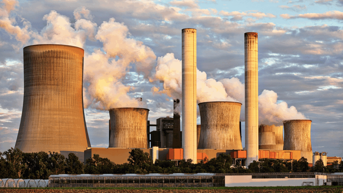 Central eléctrica con torres de enfriamiento emitiendo vapor, representando el impacto de los aranceles en la industria mexicana.