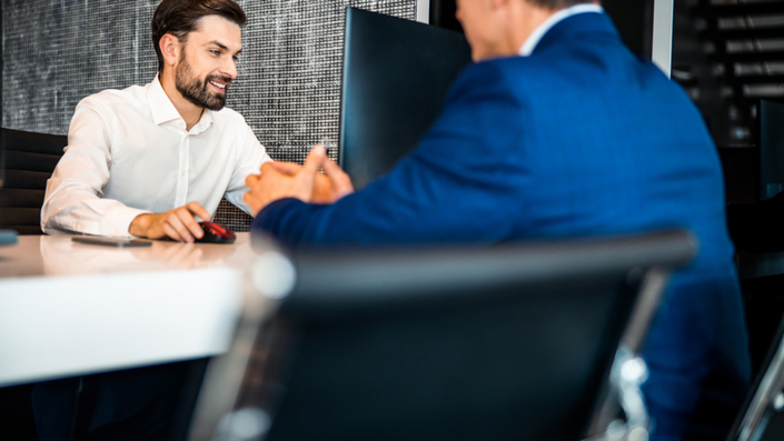 Dos personas hablando en una mesa de la oficina.