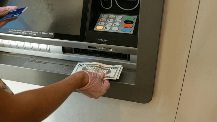 Persona utilizando un cajero automático para retirar dinero en efectivo, representando el acceso a fondos de un plazo fijo en pesos argentinos.